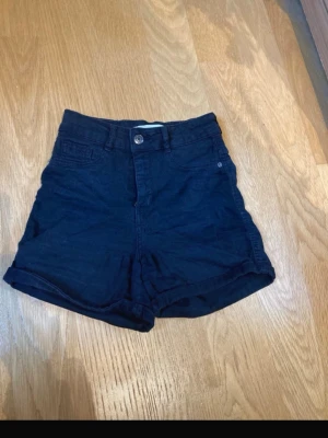 Svarta högmidjade shorts  - Säljer ett par svarta högmidjade shots. Perfekta för varma dagar och enkel att matcha med olika toppar.