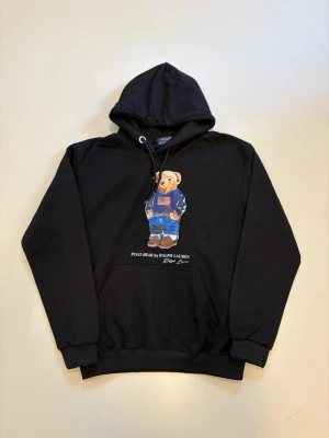 Ralph lauren björn hoodie M - Svart Ralph Lauren Polo bear hoodie //  Mycket bra skick helt oanvänd //  Storlek M //  Mått  Längd  66cm Axelbredd 49cm Bredd under armhålorna 50cm armlängd 60cm // Skriv vid minsta fråga eller fundering🤝