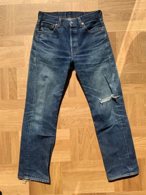 Levi’s 501xx ”553 button” - Levis 501xx med fabriksnummer 553 som förmodligen är tillverkade på Levi’s fabrik i delstaten North Carolina. Extremt hög kvalitet med en reva på framsidan och en proffesionellt gjord lagning på baksidan. Storlek w30 men utgå från måtten:  Ytterben: 99 Innerben: 75 Midja: 37 Benöppning: 19,5   Skriv vid frågor eller funderingar! /william