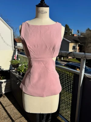 XS Rosa topp med rosett och öppen rygg - Supersnygg rosa topp i bra kvalité & med innefoder.  Ärmlös och har öppen rygg. Lika snygg till jeans eller vitt 💖