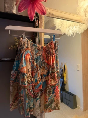 Färgglad volangkjol med mönster - Kjol med volanger och elastisk midja i ett färgglatt,  mönster med inslag av blått, orange, beige och grönt. Perfekt nu inför sommaren. 💓