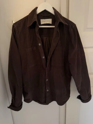 A Day's March manchester skjorta/overshirt - Säljer en brun skjorta/overshirt i manchestertyg från A Day's March. Skjortan har två bröstfickor, klassisk krage och knäppning framtill. Perfekt lager på lager-plagg med avslappnad passform och snygga detaljer. Storlek S men passar även M. Mycket bra skick. 
