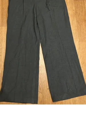 Mörkgrå kostymbyxor - Snygga mörkgrå kostymbyxor från PW Ivy med raka, vida ben och klassisk passform. Byxorna har varmare tyg så bra att ha när det är kallare eller om man är frusen av sig. Aldrig använda. 