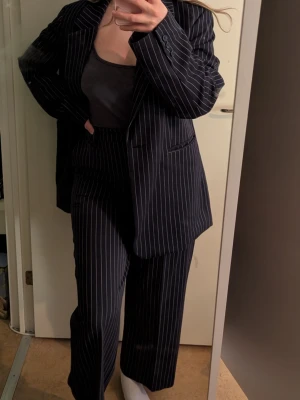 Mörkblå kostym - Snygg tvådelad kostym från bikbok. Kavajen är oversized i storlek xs/s. Byxorna är höga i midjan med raka ben och är i storlek 38. Perfekt för en trendig look😊
