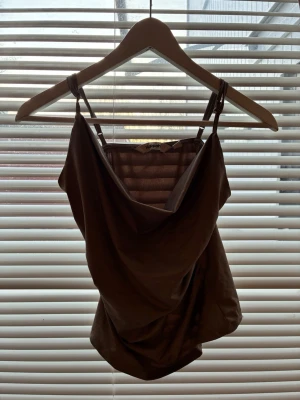 Beige linnetopp från NAKD - Säljer en beige linnetopp från NAKD med tunna axelband och snygg draperad urringning. Toppen har en figurnära passform och är perfekt att styla med jeans eller kjol. Materialet känns mjukt och lätt mot huden. Original priset ligger på 300kr och tröjan är helt oanvänd💕💕💕
