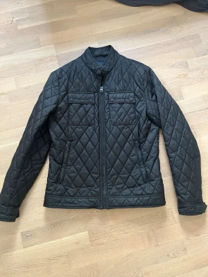 Quiltad jacka Zara Man storlek L - Quildad svart jacka från Zara Man i storlek L. Lite slitet på framsidan vid dradkedjan enligt bild 5, annars fint skick. Tunnt fodrad så den passar som vår eller höstjacka
