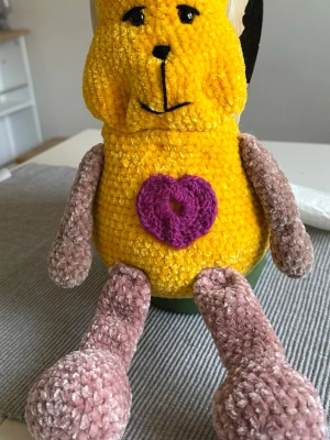 Virkad agurimi figur - Den här är virkad i mjukt och mysigt garn! Passar bra som present till ett litet barn! Ansiktet går att forma lite med fingrarna! Den har även ett hjärta sytt på magen och en blomma på huvudet!