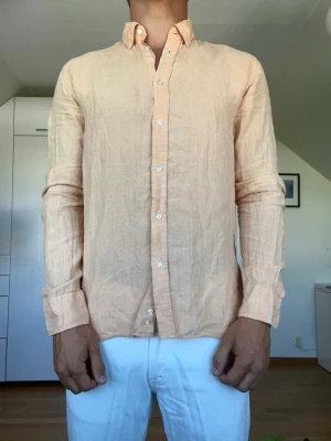 Orange linneskjorta  - Orange skjorta tillverkad i 100% linne från märket Bläck. Strl S. Inga defekter. Modellen är 178 cm och väger 77 kg. Hör gärna av dig vid frågor!