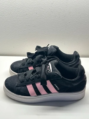 Adidas campus 00s - Säljer dessa svarta campus med rosa stripes i storlek 38❣️använd fåtal gånger, väldigt bra skick!