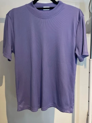 Lila T-shirt - En lila ribbad t-shirt från Jacett, storlek L.