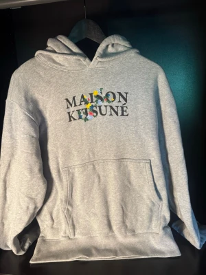 Maison kitsune Hoodie - Snygg grå hoodie från Maison Kitsuné med logga. Inte andvänd mycket. Storlek s vilket är svårare att hitta och lite dyrare. Säljer den billigt då jag åker bort och vill ha lite extra pengar. Skickar direkt. Skriv vid intresset eller om det är något specifikt ni vill se.