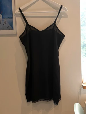 Svart nattlinne med spetsdetaljer - Gullig svart mini klänning. Lite genomskinligt tyg och med spets längst ner. Storlek 42.  köpt secondhand. Använd av mig ca 3 gånger.