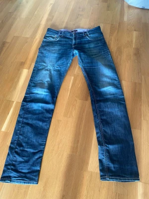 Blåa jeans - Snygga och fräscha jeans från märket Sand. Tidigare ägaren har sytt på dem, men tycker det ser bra ut ändå. Inga fler defekter och sitter helt perfekt runt benen enligt mig 
