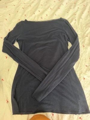 Mörkblå långärmad topp Intimissimi - Mörkblå långärmad topp från Intimissimi i en mjuk blandning av ull och kashmir. Enkel och stilren design med rund halsringning och figurnära passform. Perfekt att styla lager på lager eller bära som den är.