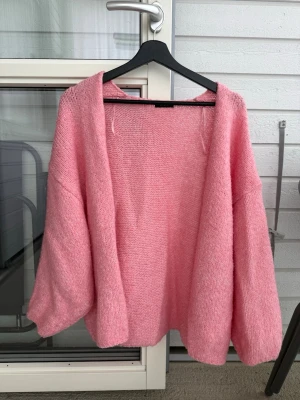 Lindex rosa stickad kofta - Superfin rosa färg från en tidigare kollektion som inte längre finns att köpa längre. Etiketten är bortklippt men storleken är XL/2XL. Oversized i storleken och ej stickig alls då den inte innehåller ull. Lite nopprig men annars hel o fin 💓💓