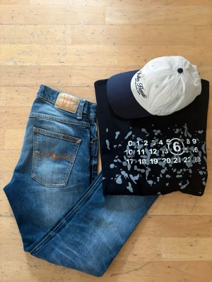 Nudie grim tim jeans - Säljer ett par snygga nudie jeans i modell grim tim, har ett hål (se bild). Men detta går att laga gratis hos nudie butiker  30x30
