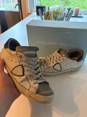 Philippe Model strl 41 - Snygga vita sneakers från Philippe Model med beige mockadetaljer på tån och svart hälparti. Självklart äkta har sätt bättre dagar men funkar nog att limas lite så är de som nya har nog vart så här ett bra tag nu och inget jag bryr mig om. Box medföljer 