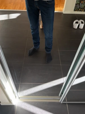 Replay jeans  - Säljer ett par mörkblå slim fit jeans med klassisk femficksdesign och kontrastsömmar. Jeansen har normal midja och smal passform hela vägen ner. Perfekta till vardags och lätta att matcha med olika stilar. 31/34 i storlek, modellen är 185 cm och 70 kilo 