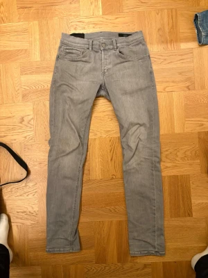 Grå dondup jeans - Säljer ett par gråa slim fit jeans. Jeansen har en enkel och stilren look som passar till det mesta. Materialet känns mjukt och följsamt, perfekt för dig som gillar en smalare passform. Typ aldrig använda och riktigt snygga