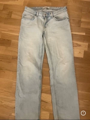 Ljusblå low waist jeans - Säljer ett par ljusblå jeans med rak passform och klassisk femficksdesign. Jeansen har normal midja och är tillverkade i denim med en snygg tvättad look. Perfekta för en avslappnad och trendig stil.