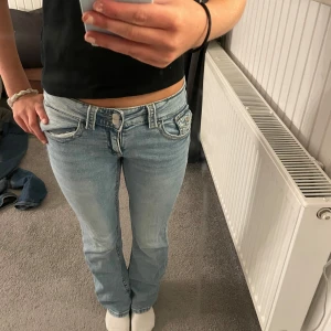 Ljusblå bootcut jeans låg midja - Säljer ett par ljusblå jeans med låg midja och bootcut-ben. Jeansen har klassiska fem fickor och sparsamt använda🥰.