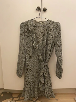 Söt långklänning  - Fin prickig kort klänning, en omlott klänning så man knyter runt den. V ringning. 
