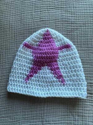 Virkad mössa - Egentillverkad virkad mössa i vitt och rosa garn med en stjärna på. Tvättas i 30 grader