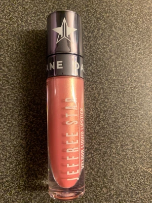 Jeffree Star Velour Liquid Lipstick Ryland - Snyggt flytande läppstift från Jeffree Star i nyansen Ryland. Färgen är en skimrande persikorosa med metallic-finish. Kommer i en genomskinlig tub med silvrigt lock och tydlig logga. Perfekt för dig som vill ha ett statement på läpparna.