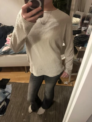 Beige ribbad tröja från Anna Field - Säljer en beige långärmad tröja från Anna Field med ribbad struktur och rund halsringning. Tröjan har en avslappnad passform och är perfekt för lager på lager. Enkel och stilren design som passar till det mesta.