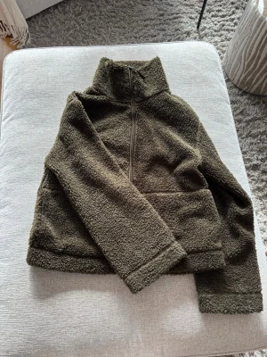 mörkgrön teddyjacka med dragkedja - Mysig grön teddyjacka i fluffigt material med hög krage!