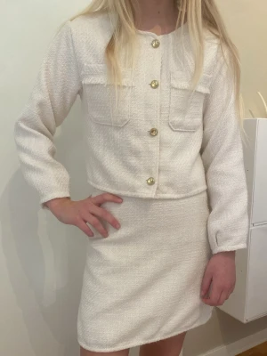 Vit kjol med en tröja - Ett nytt kit från HM med en kjol och en tröja. Den är i nytt skick och i färgen vit. Kontakta för frågor.