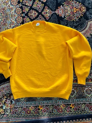 Gul sweatshirt i bomull - En enkel och stilren gul sweatshirt med rund hals och långa ärmar. Tröjan har ribbade muddar vid ärmslut och nederkant. Perfekt för dig som vill ha en färgklick i garderoben. Tillverkad i mjuk bomull för skön komfort.
