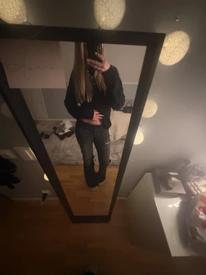 Svarta bootcut jeans med dubbla knappar - Säljer ett par svarta bootcut jeans med snygg tvätt och dubbla vita knappar i midjan. Jeansen har raka ben och stora fickor fram.  Hål i knäna. Från Gina tricot i storlek 170