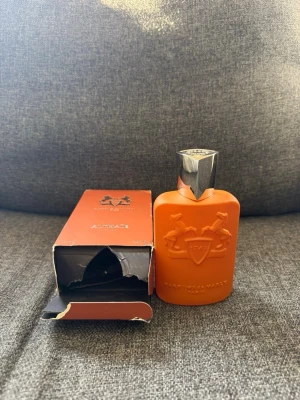 Parfums de Marly Althaïr EdP - Parfymen Althaïr. OBS! Kartongen är i väldigt slitet skick och jag rekommenderar er att vara varsam när ni öppnar paketet så parfymen tine trillar och går i sönder. Själva parfymen i sig har inga defekter och är så gott som ny. Skulle nog säga ca 109ml kvar🌺