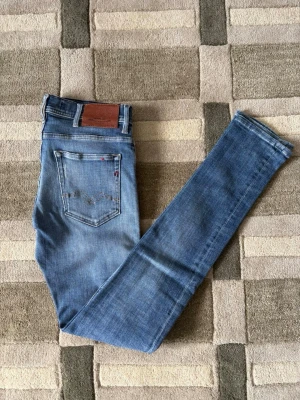 Replay jeans - Ett par riktigt snygga par replay jeans med snygga slitningar som är modernt i en lite ljusare blå färg. Hör av er vid frågor eller funderingar!