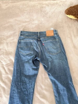 Levi's 511 blå jeans W32 L32 - Säljer ett par klassiska blå Levi's 511 jeans med raka ben och normal midja.levi's ikoniska läderpatch bak och röd logotagg på bakfickan. Tillverkade i slitstark denim av bomull. Perfekta för en avslappnad och tidlös stil. 