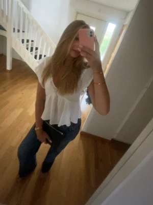 Blåa raka/breda jeans med låg midja - Säljer ett par blåa jeans med låg midja och raka/breda ben. Jeansen har klassisk femficksdesign och stängs med dragkedja och knapp. Perfekta för en trendig och avslappnad look även en liten sliten look.