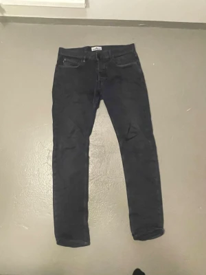 Svarta jeans från Stone Island - Snygga svarta jeans från Stone Island med klassisk femficksmodell och raka ben. Jeansen har knappgylf och diskreta sömmar, perfekta för en stilren och modern look. Materialet känns mjukt och följsamt, vilket gör dem bekväma att bära hela dagen.