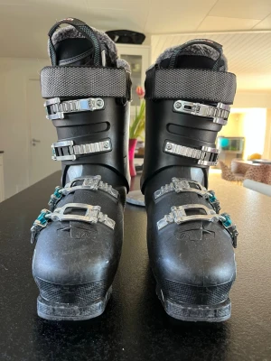 Svarta pjäxor Roxa R Fit 75 W - Snygga svarta pjäxor från Roxa, modell R Fit 75 W. De har fyra justerbara spännen i silver och turkos, samt grått innerfoder. Pjäxorna är märkta med 'ultralight' och 'bio fit' och passar perfekt för skidåkning.  Dam päxa men den har funkat lika bra för herr åkning tycker jag, de är använda mycket med försiktighet, storlek: 275cm/310cm