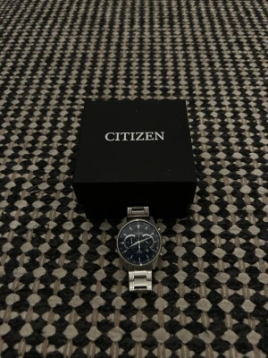 Citizen herrklocka i silver - Stilren klocka från Citizen med blå urtavla och silverfärgat armband i metall. Klockan har flera små urtavlor och klassisk design som passar perfekt till alla tillfällen. Levereras i originalask. Skriv vid frågor, priset är inte fast