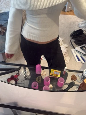 Vit off shoulder stickad tröja - Trendig vit stickad tröja med off shoulder-design och bred ribbad kant upptill. Figurnära passform och långa ärmar ger en snygg siluett. Perfekt att matcha med jeans eller kjol för en stilren look.