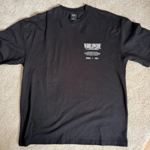 T-shirt från New Yorker  - Säljer en svart t-shirt från New yorker med tryck fram och stort motiv av två vita duvor samt text på ryggen. T-shirten har oversize passform och är gjord i mjuk bomull. Perfekt för dig som gillar streetwear och snygga prints.