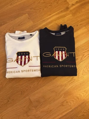 Gant sweatshirts 399 för båda - Vit sweatshirts och marinblå sweatshirt från Gant i mjuk bomullsblandning med rund halsringning och ribbade muddar vid ärmslut och nederkant. Lång ärm och avslappnad passform. 
