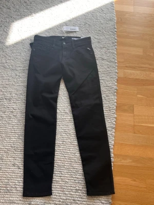 Svarta slim jeans från Replay - Snygga svarta slim fit jeans från Replay med ordinariepris på 1299, klassisk femficksdesign och diskret logga på fickan. Jeansen är aldrig används och har raka ben och är tillverkade i ett mjukt denimtyg med lite stretch för extra komfort. Priset är inte hugget i sten så kommer gärna med prisförslag 🤩