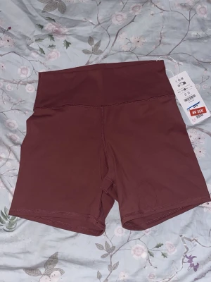 Bruna högmidjade bikershorts från Berska - Snygga bruna bikershorts från Berska med hög midja och tight passform. Tillverkade i ett stretchigt syntetmaterial som passar perfekt till träning. Stilren design utan mönster och med diskret logga bak.