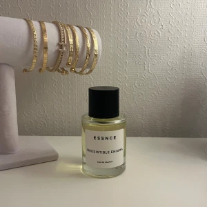 ESSNCE Irresistible Enigma EdP - Helt ny populär Eau de Parfum från ESSNCE (endast använt få sprut). Innehåller päron, mandarin, bergamott, apelsinblomma, jasmin, neroli, bourbon vanilj, vit mysk, amber och benzoin. Perfekt för dig som vill sticka ut med en modern och fräsch vibe samt dig som gillar orada paradox.
