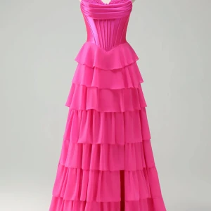 Balklänning  - Superfin långklänning i stark rosa med axelbandslös design och markerat korsettliv i satin. Kjolen har flera lager volanger som ger en dramatisk och flowy känsla. Perfekt för dig som vill sticka ut och älskar färg och volym. Klännigen är uppsydd i längden så att den nuddar marken med 10 cm klackar. Den är även syg i midjan vilken passar S-Xs