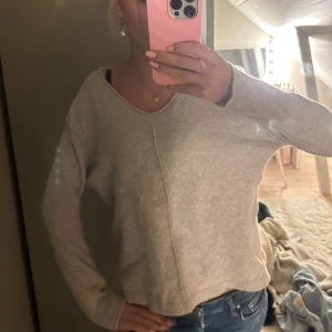 Beige stickad tröja med v-ringning - SMysig beige stickad tröja med v-ringad hals och synlig söm framtill. Tröjan är från isay och är så mysig t hösten🤍🍁