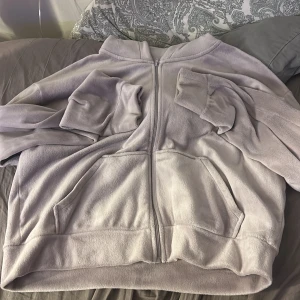 Ljuslila fleece hoodie med dragkedja - Supermjuk och mysig ljuslila hoodie i fleece med dragkedja framtill och stora fickor. Perfekt för kyliga dagar och har en skön huva samt långa ärmar med muddar. Enkel och stilren design som passar till allt.