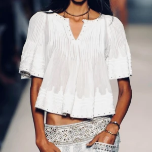 Isabel Marant Iconic Rare Embroidered Alexia Blouse 2013 S/S Runway Collection - ♡ Stunning rare Alexia blouse by Isabel Marant from the 2013 S/S (Spring/Summer) runway collection. One of her most iconic pieces. ♡ Embroidered eyelet pleated blouse with accented brass stud and grommets around neckline, arm cuffs and hem.♡ Excellent condition. ♡ Size FR38. ♡ 100% cotton, eyelets 100% laiton brass, rivets 100% laiton brass. 